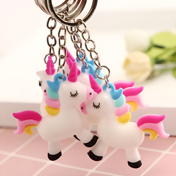 Plusieurs porte-clés licorne avec des corps blancs, des crinières et des queues colorées (rose, bleu, jaune) suspendus à des chaînes argentées. Les licornes ont des yeux fermés en forme de croissant., 45501160587519 | Licorne Shop