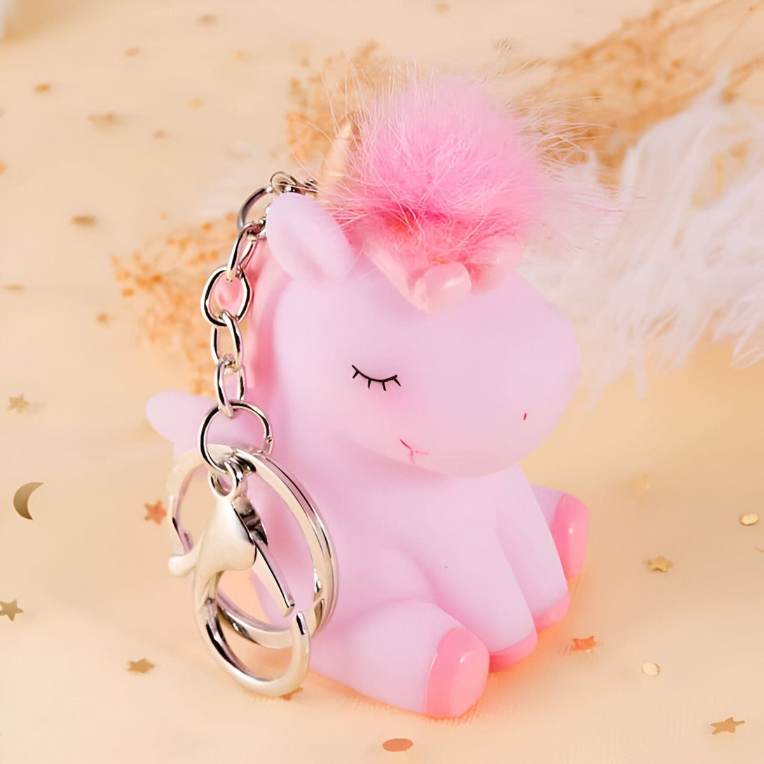 Image d'un porte-clés mignon en forme de licorne rose avec une queue de cheval en fausse fourrure rose. La licorne a un visage souriant et des yeux fermés. Le porte-clés est en métal argenté., 45501158850815 | Licorne Shop