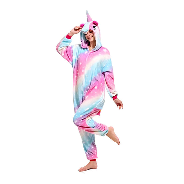 Une femme portant un pyjama licorne coloré avec une capuche avec une corne. Le pyjama est rose, bleu et blanc avec des étoiles. Elle sourit et lève une main., 45502357504255,45502357537023,45502357569791,45502357602559,45502357635327,45502357668095,45502357700863,45502357733631 | Licorne Shop