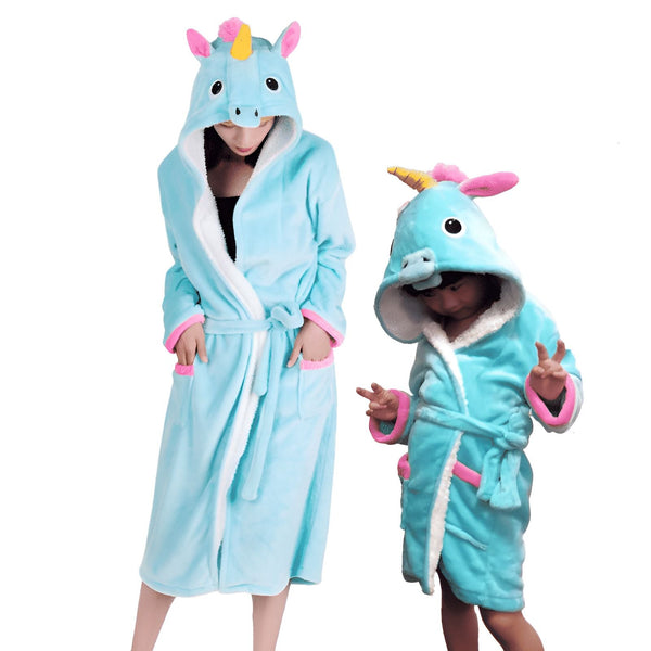 Une femme et un enfant portent des peignoirs en flanelle bleu turquoise à capuche, décorés comme des licornes roses et jaunes. Les peignoirs ont des poches et des ceintures assorties. Idéal pour les moments douillets à la maison., 45502359503103,45502359535871,45502359568639,45502359601407,45502359634175,45502359666943,45502359699711,45502359732479 | Licorne Shop