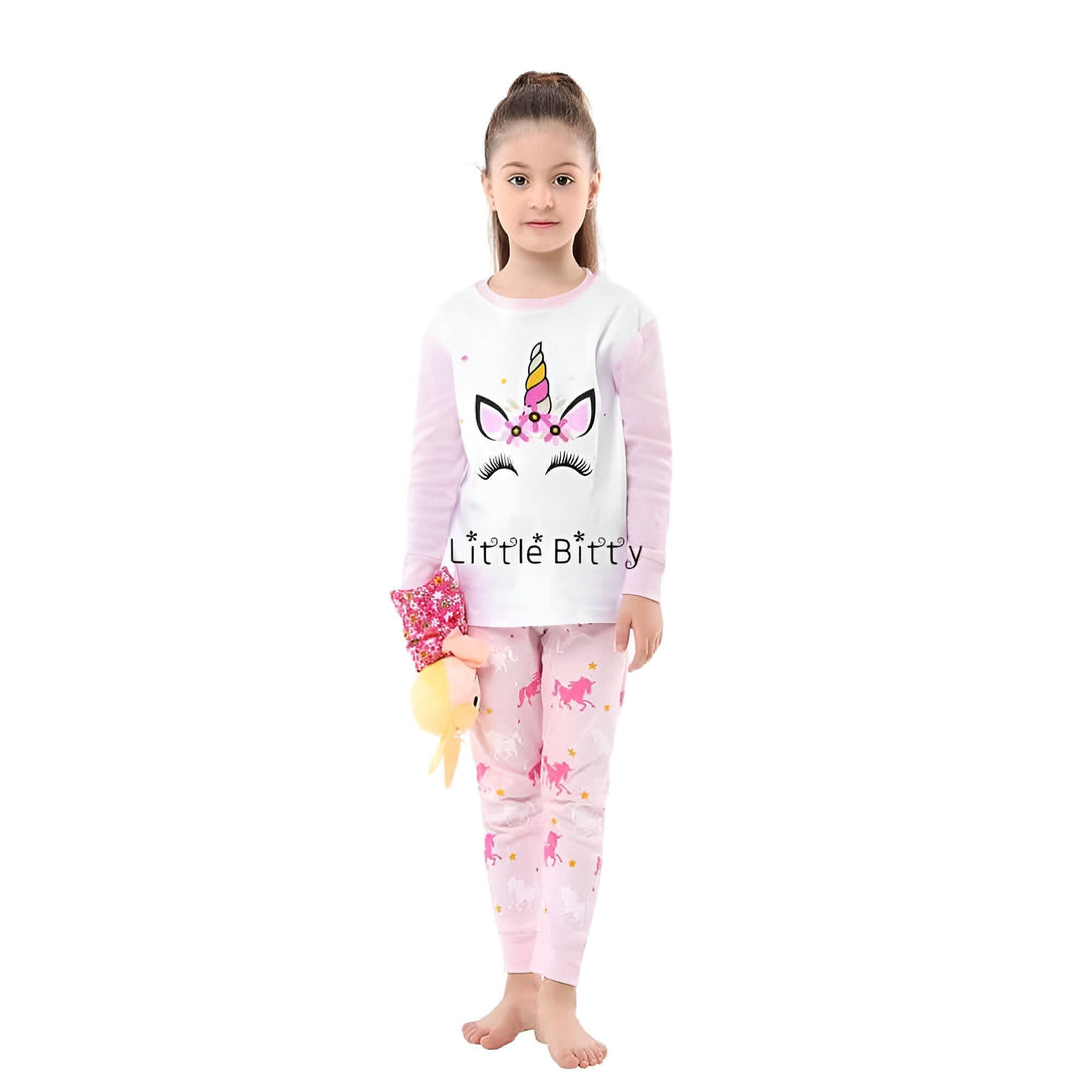 Jeune fille portant un pyjama rose et blanc avec motif licorne, tenant une poupée. Pyjama confortable pour enfants, motif adorable licorne, vêtements de nuit pour filles., 45501994238207,45501994270975,45501994303743,45501994336511,45501994402047,45501994434815,45501994467583,45501994500351 | Licorne Shop