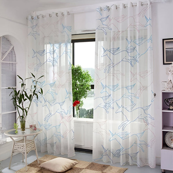 Rideaux blancs transparents avec motifs d'unicorne bleus et roses. Décoration intérieure lumineuse et aérée. Table en rotin et coussin sur tapis tissé. Fenêtre avec vue sur la verdure., 45501076537599 | Licorne Shop