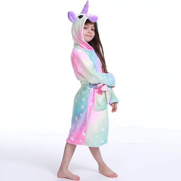 Enfant portant un peignoir licorne coloré avec capuche. Le peignoir est décoré d'étoiles et a une ceinture assortie. La fillette sourit et regarde sur le côté, les bras croisés. Vêtement de nuit amusant et confortable pour enfants., 45502347510015,45502347542783,45502347575551,45502347608319,45502347641087,45502347673855,45502347706623,45502347739391 | Licorne Shop