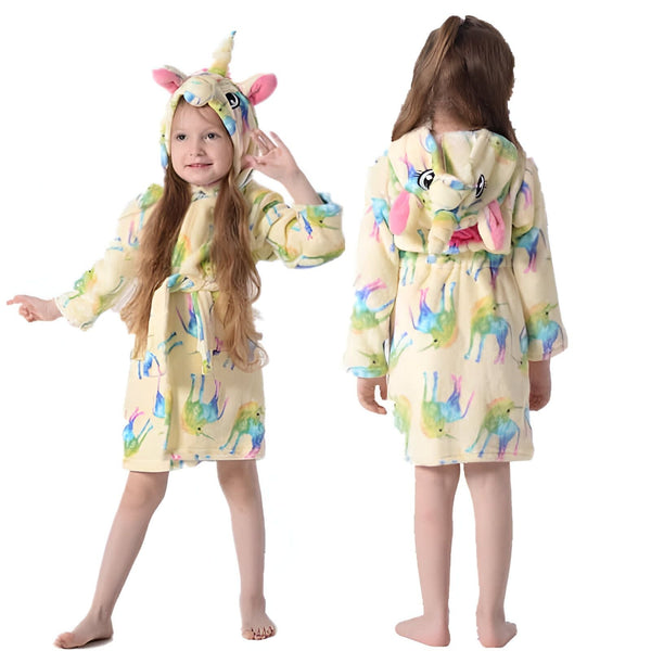 Une fillette porte un peignoir jaune à capuche avec motif de licorne. Le peignoir a une ceinture et des oreilles de licorne sur la capuche. La fillette est visible de face et de dos., 45502045880575,45502045913343,45502045946111,45502045978879,45502046011647,45502046044415,45502046077183,45502046109951 | Licorne Shop
