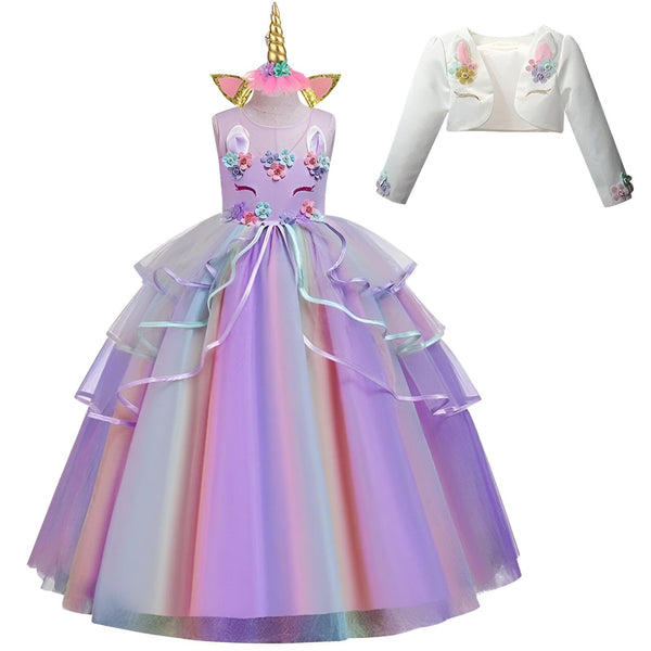 Une robe de licorne violette et blanche avec une jupe en tulle arc-en-ciel, des fleurs et des paillettes. La robe est livrée avec un serre-tête licorne assorti.