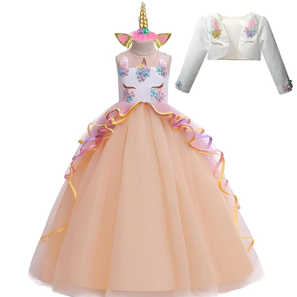 Une robe de princesse en tulle rose et blanc avec des fleurs et des paillettes. La robe a une longue traîne et un boléro assorti.