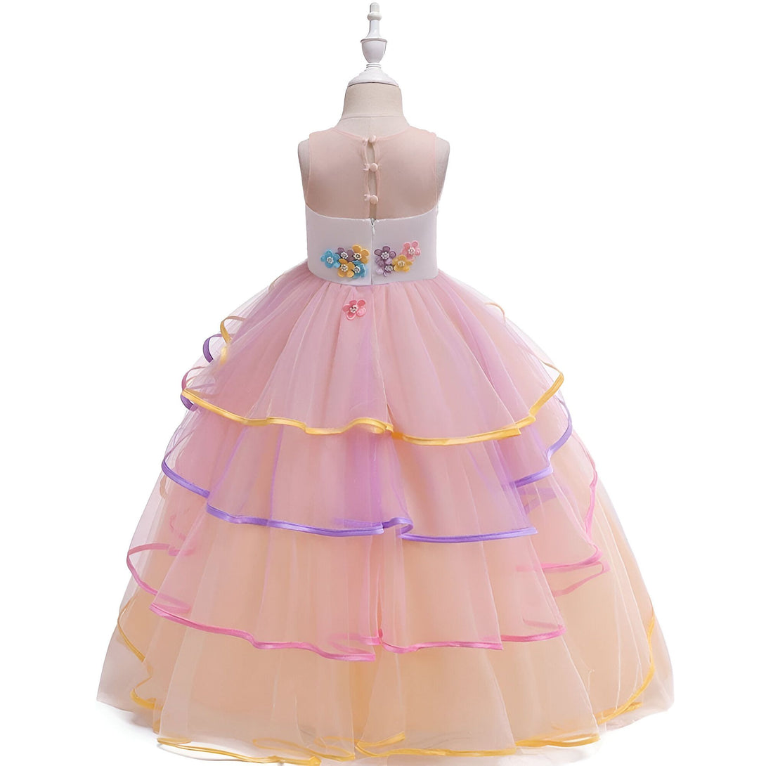 Une robe de princesse en tulle rose et jaune avec des fleurs en 3D et des rubans colorés.