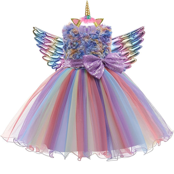 Une robe de licorne avec des ailes et une corne. La robe est faite de fleurs en mousseline de soie et de tulle. Les ailes sont en plastique et recouvertes de paillettes. La robe est disponible en plusieurs couleurs.