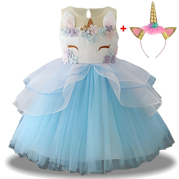 Une robe de licorne bleue et blanche avec des fleurs et une licorne sur le devant. La robe est livrée avec un serre-tête licorne.