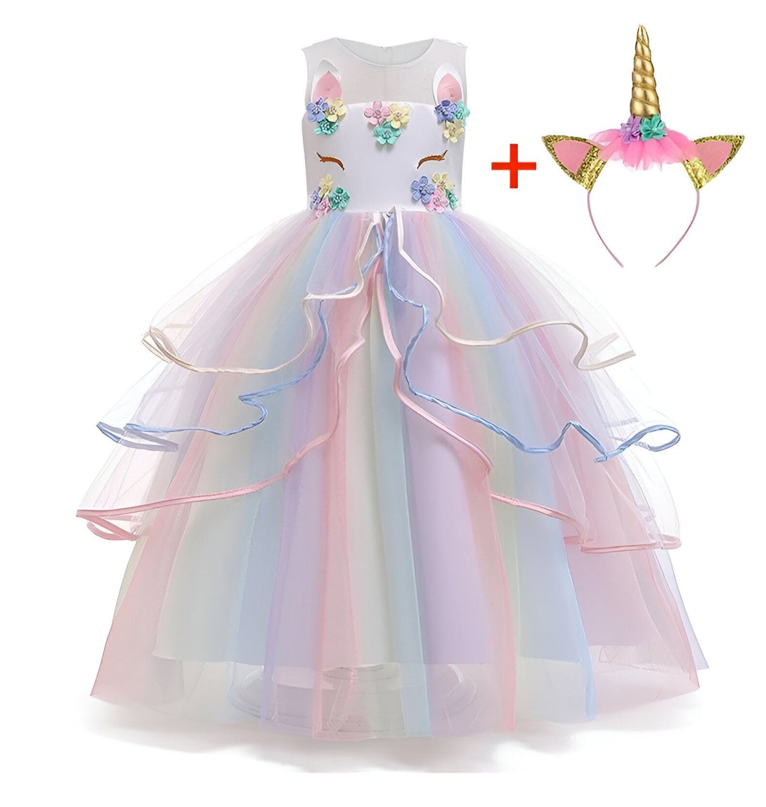 Une robe de licorne blanche et rose avec des fleurs et des paillettes. La robe est composée de plusieurs couches de tulle et est très volumineuse. Elle est accompagnée d'un serre-tête avec une corne de licorne.