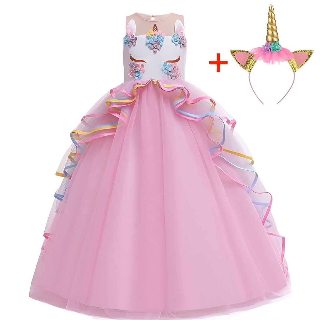 Une robe de princesse rose avec une licorne. La robe est en tulle et a plusieurs couches de volants. Elle est décorée de fleurs et de paillettes. La licorne est en peluche et a une corne dorée.