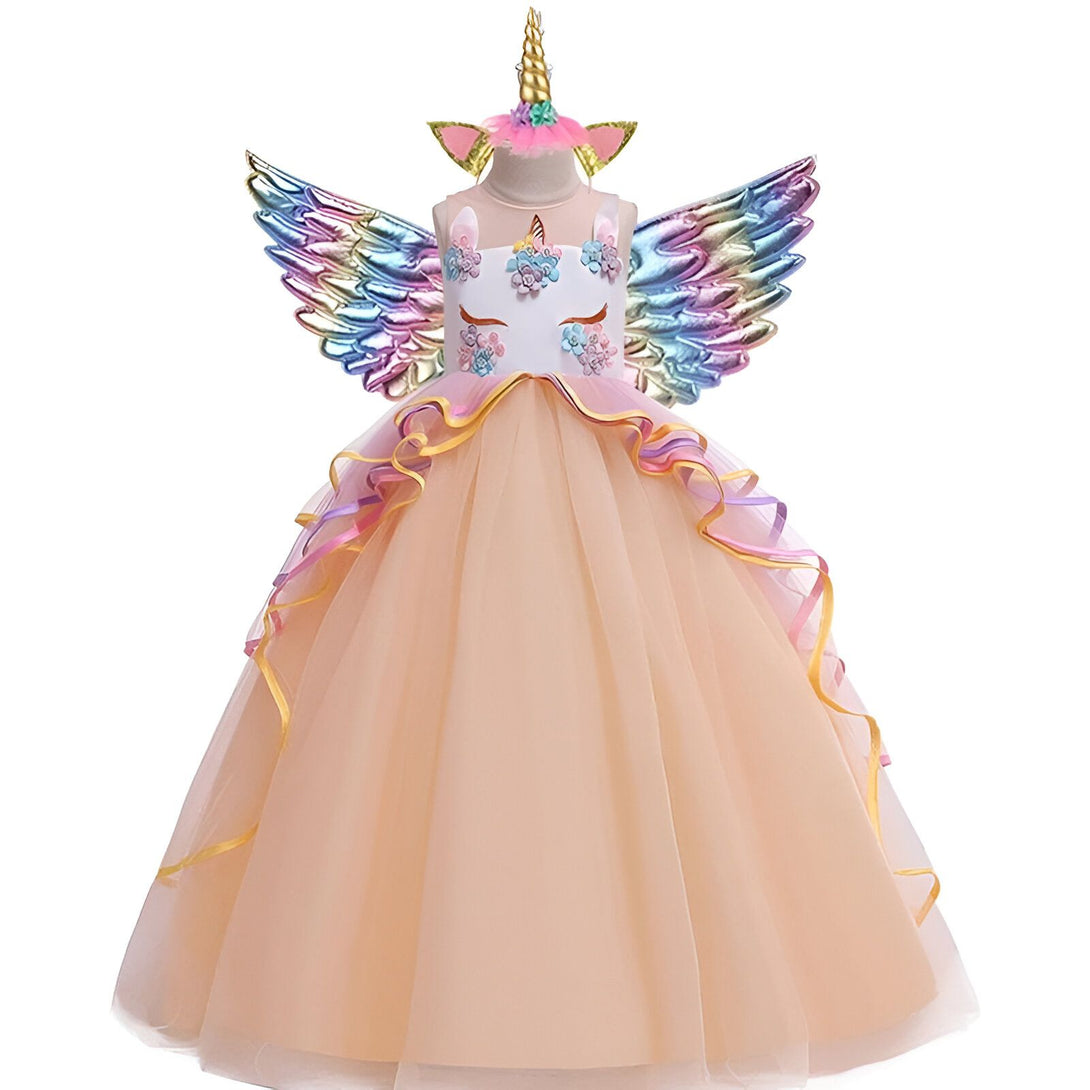 Une robe de princesse en tulle avec des ailes de licorne et une coiffe. La robe est de couleur rose et blanche avec des fleurs en 3D et des paillettes. Les ailes sont de couleur arc-en-ciel et la coiffe est une corne de licorne.