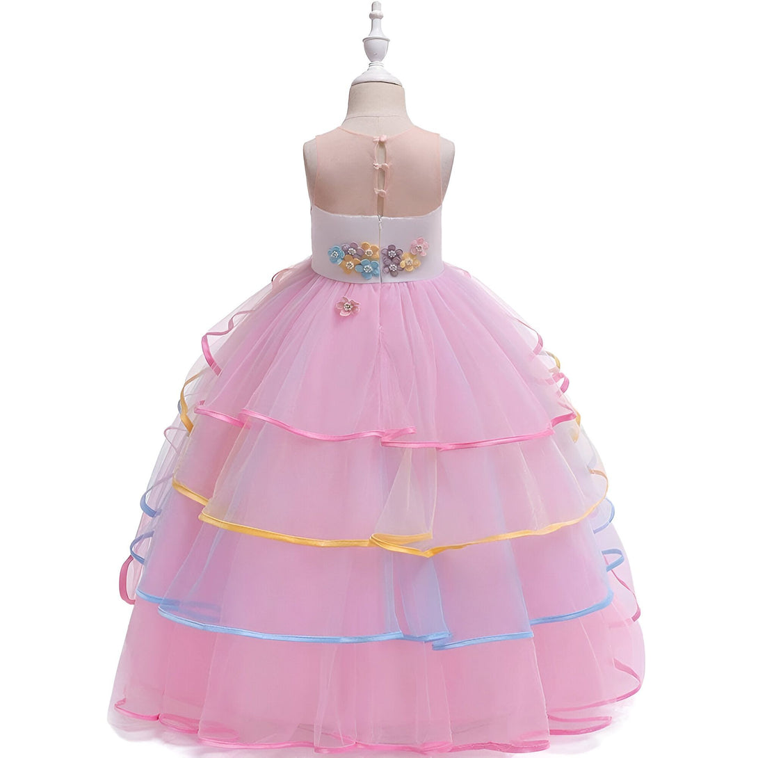 Une robe de princesse rose à plusieurs volants avec des fleurs en 3D et des rubans de couleur pastel