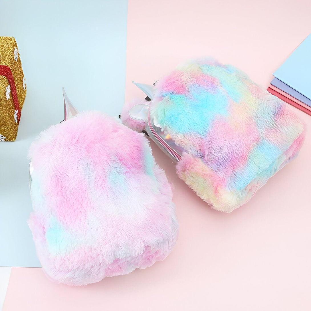 Une image de deux sacs à dos en peluche de couleur arc-en-ciel avec des cornes de licorne.