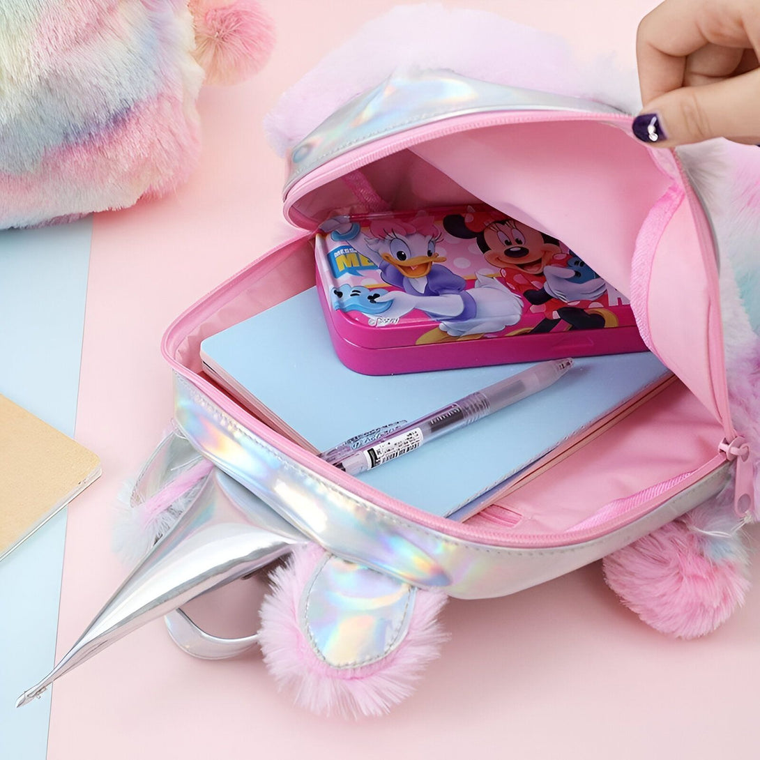 Une image d'un sac à dos licorne en peluche rose et blanche avec une trousse à l'intérieur.