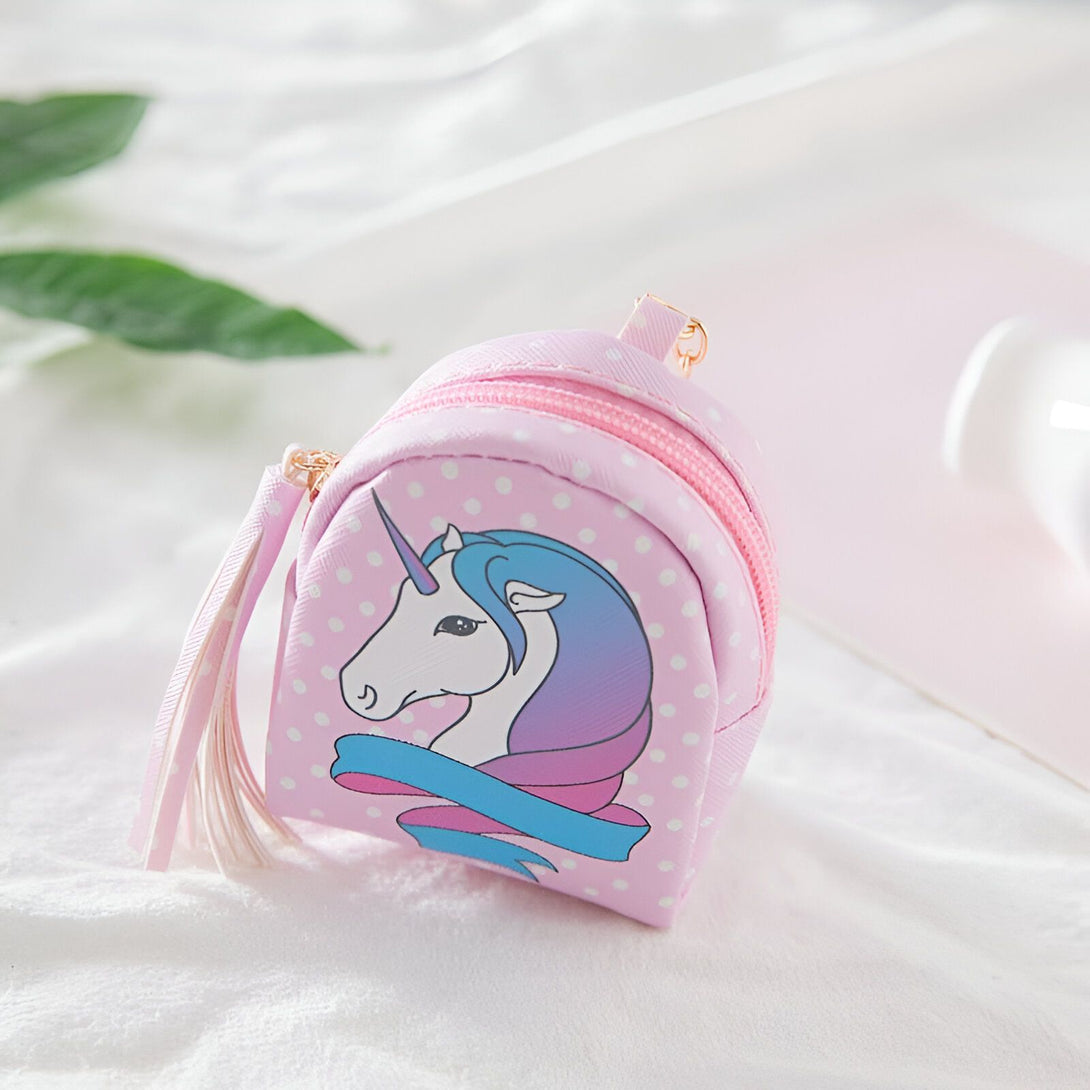 Mignon petit porte-monnaie rose à pois blancs en forme de sac à dos, orné d'un dessin de licorne avec une crinière bleue et violette, et un ruban turquoise. Fermeture éclair dorée et détails soignés., 45501374955775 | Licorne Shop