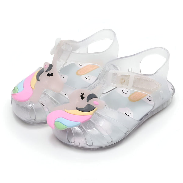Paire de sandales de plage transparentes pour enfants, décorées avec des têtes de licorne colorées à l'avant. Le fond des sandales présente des motifs de nuages et de biscuits souriants. Fermeture par boucle. Idéales pour l'été et les jeux d'eau., 45502056235263,45502056268031,45502056300799,45502056333567,45502056366335,45502056399103,45502056431871,45502056464639,45502056497407 | Licorne Shop