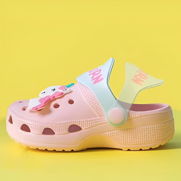 Gros plan d'une chaussure sabot rose pour enfant avec un motif de licorne et le mot "ORN" dessus, placée sur un fond jaune uni. Chaussure décontractée pour filles, tendance et confortable., 45502046306559,45502046339327,45502046372095,45502046404863,45502046437631,45502046470399,45502046503167,45502046535935,45502046568703 | Licorne Shop