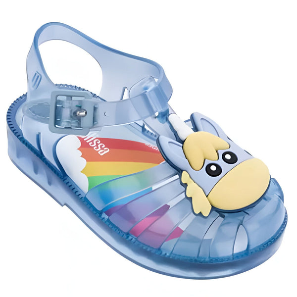 Sandale Melissa pour enfant, en plastique bleu transparent. Motif d'une tête de licorne jaune et bleue sur le dessus. Semelle intérieure avec un arc-en-ciel., 45502346625279,45502346658047,45502346690815,45502346723583,45502346756351,45502346789119,45502346821887,45502346854655,45502346887423 | Licorne Shop