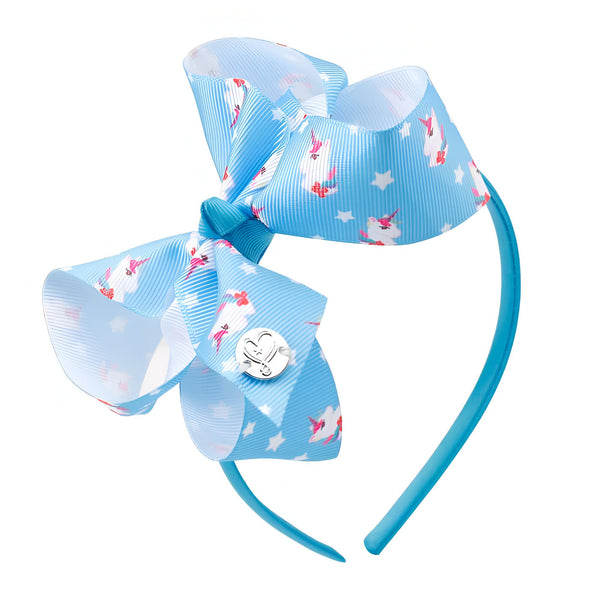 Serre-tête bleu avec un grand nœud imprimé de motifs de licornes et d'étoiles blanches. Il y a un bouton argenté en forme de cœur., 45501375250687 | Licorne Shop