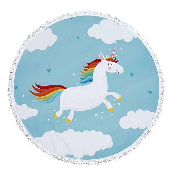 Serviette de plage ronde avec motif d'un licorne blanc, crinière et queue arc-en-ciel, sur un fond bleu ciel avec des nuages blancs et des petites étoiles. La serviette a une bordure à franges blanches., 45501225861375 | Licorne Shop
