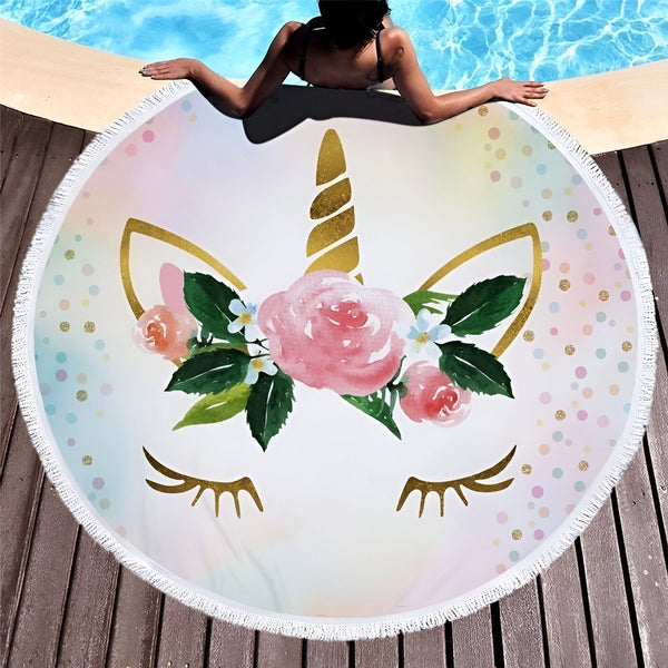 Serviette de plage ronde avec motif de licorne près d'une piscine. Femme se relaxant sur la serviette. Design floral et couleurs pastel. Franges blanches sur le bord. Idéal pour l'été et les vacances., 45501225631999 | Licorne Shop