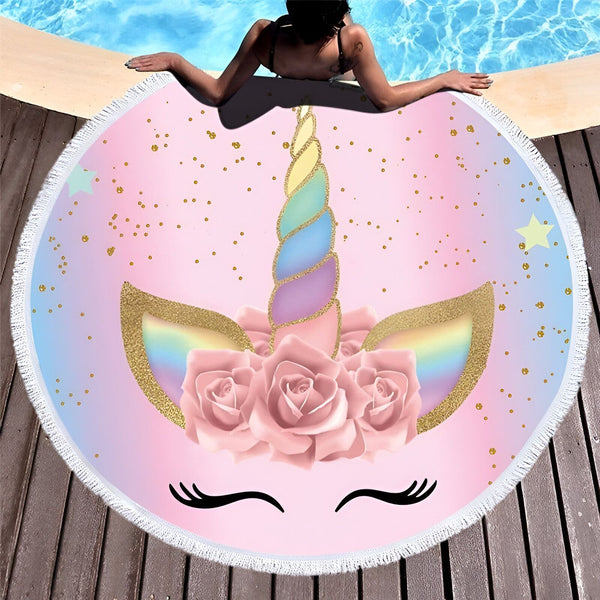 Une personne se détend près d'une piscine sur une serviette de plage ronde avec un motif de licorne colorée, avec un fond rose et bleu, des paillettes dorées et des détails floraux., 45501255090431 | Licorne Shop