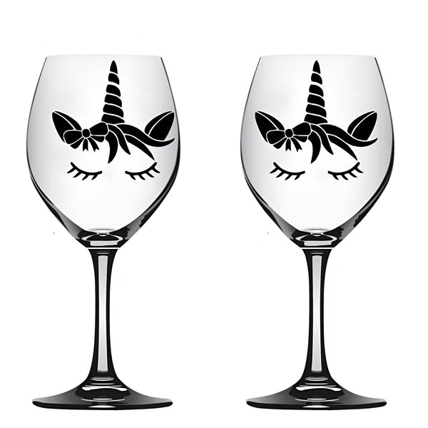 Deux verres à vin transparents décorés d'une silhouette noire de licorne stylisée, avec des cils fermés, un nœud et une corne. Idéal pour une décoration de table féérique ou un cadeau original., 45501134471423 | Licorne Shop