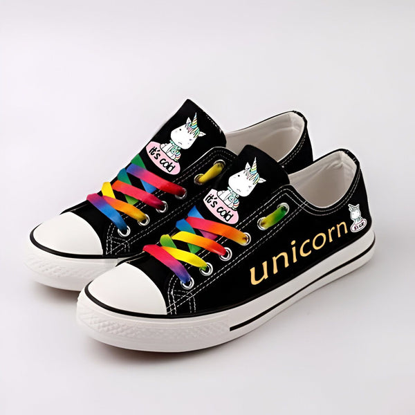 Paire de baskets basses noires avec des lacets arc-en-ciel. Elles sont décorées d'un motif de licorne et du mot "unicorn" en doré. Style décontracté et fun., 45502169874687,45502169907455,45502169940223,45502169972991,45502170005759,45502170038527,45502170071295,45502170104063,45502170136831 | Licorne Shop