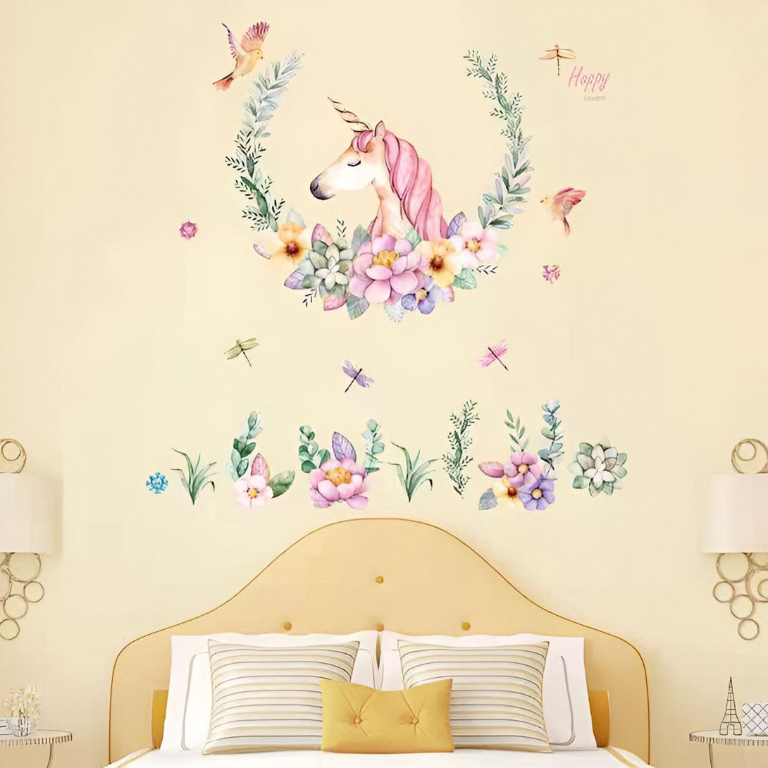 Une illustration d'une licorne avec des fleurs et des oiseaux. La licorne est au centre de l'image, avec des fleurs de chaque côté et des oiseaux qui volent au-dessus. Les fleurs sont de différentes couleurs, notamment du rose, du jaune et du violet. Les feuilles sont vertes. La licorne est blanche avec une crinière et une queue roses. Les oiseaux sont bleus et verts. L'arrière-plan est blanc.