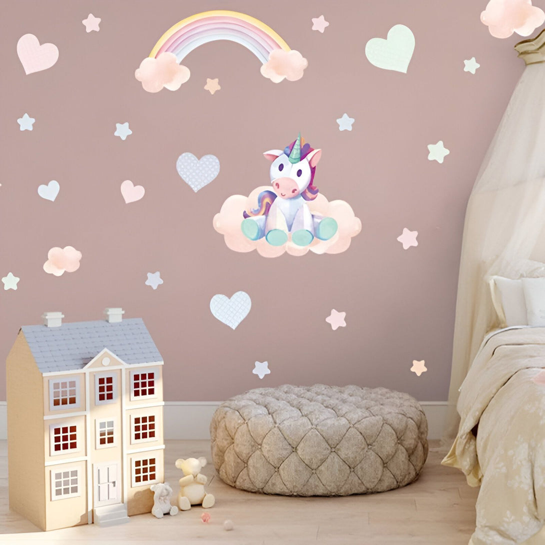 Une chambre d'enfant avec une décoration de licorne. Il y a un lit, une maison de poupée, un pouf et des nuages, des étoiles et des cœurs en guise de décoration murale.