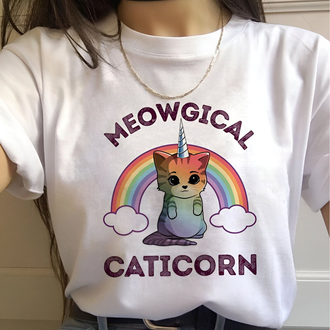 Une image d'un chat licorne avec une corne et une crinière arc-en-ciel. Le chat est assis sur un nuage et il y a un arc-en-ciel derrière lui. Le texte sur l'image dit "Meowgical Caticorn".