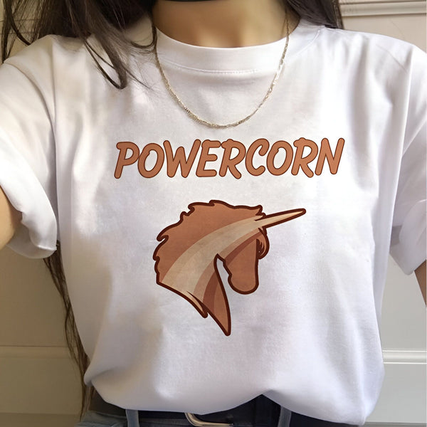 Une femme porte un t-shirt blanc avec un imprimé marron. Le texte imprimé est "Powercorn".