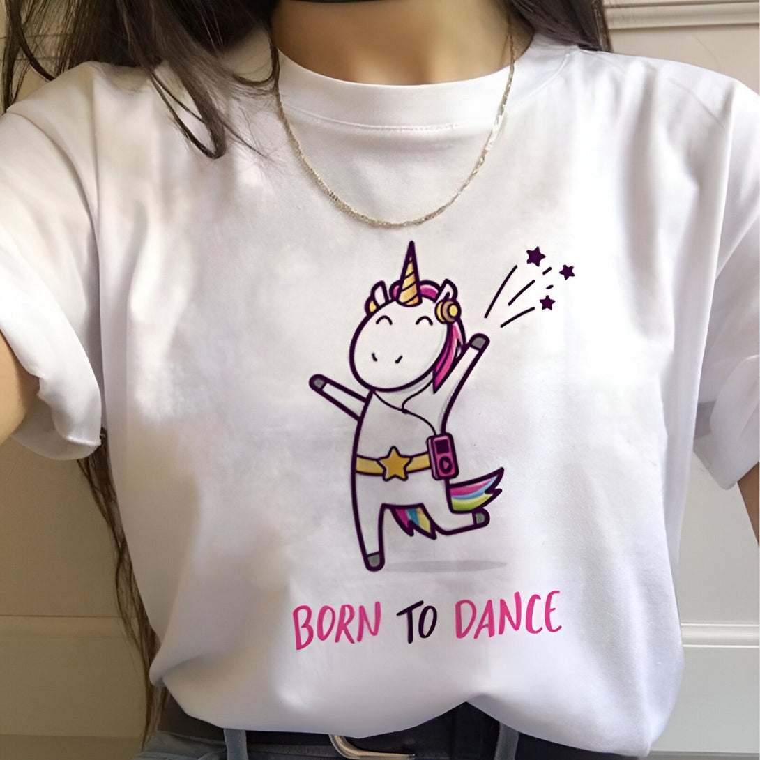 Une illustration d'une licorne blanche avec des étoiles filantes et un lecteur mp3 rose autour de la taille. La licorne danse et porte des écouteurs blancs. Le texte "Born to Dance" est écrit en rose sous la licorne.