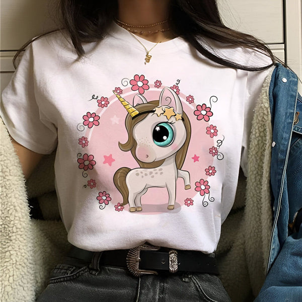 Une jeune femme porte un t-shirt blanc avec un motif de licorne. La licorne est entourée de fleurs et d'étoiles.