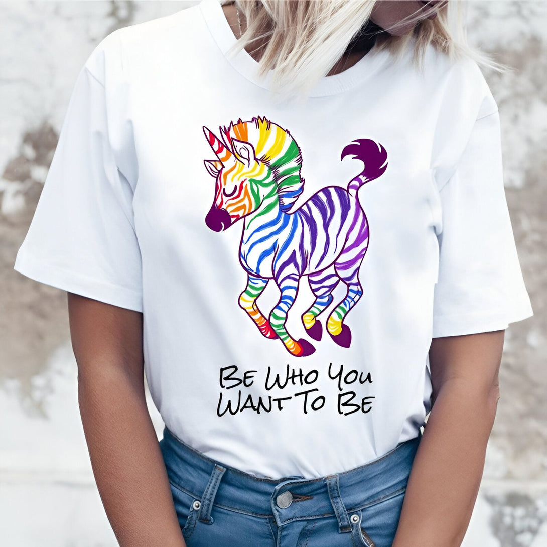 Une image d'un zèbre avec une corne de licorne. Le zèbre est coloré avec les couleurs de l'arc-en-ciel. Il y a du texte en dessous qui dit "Be who you want to be".