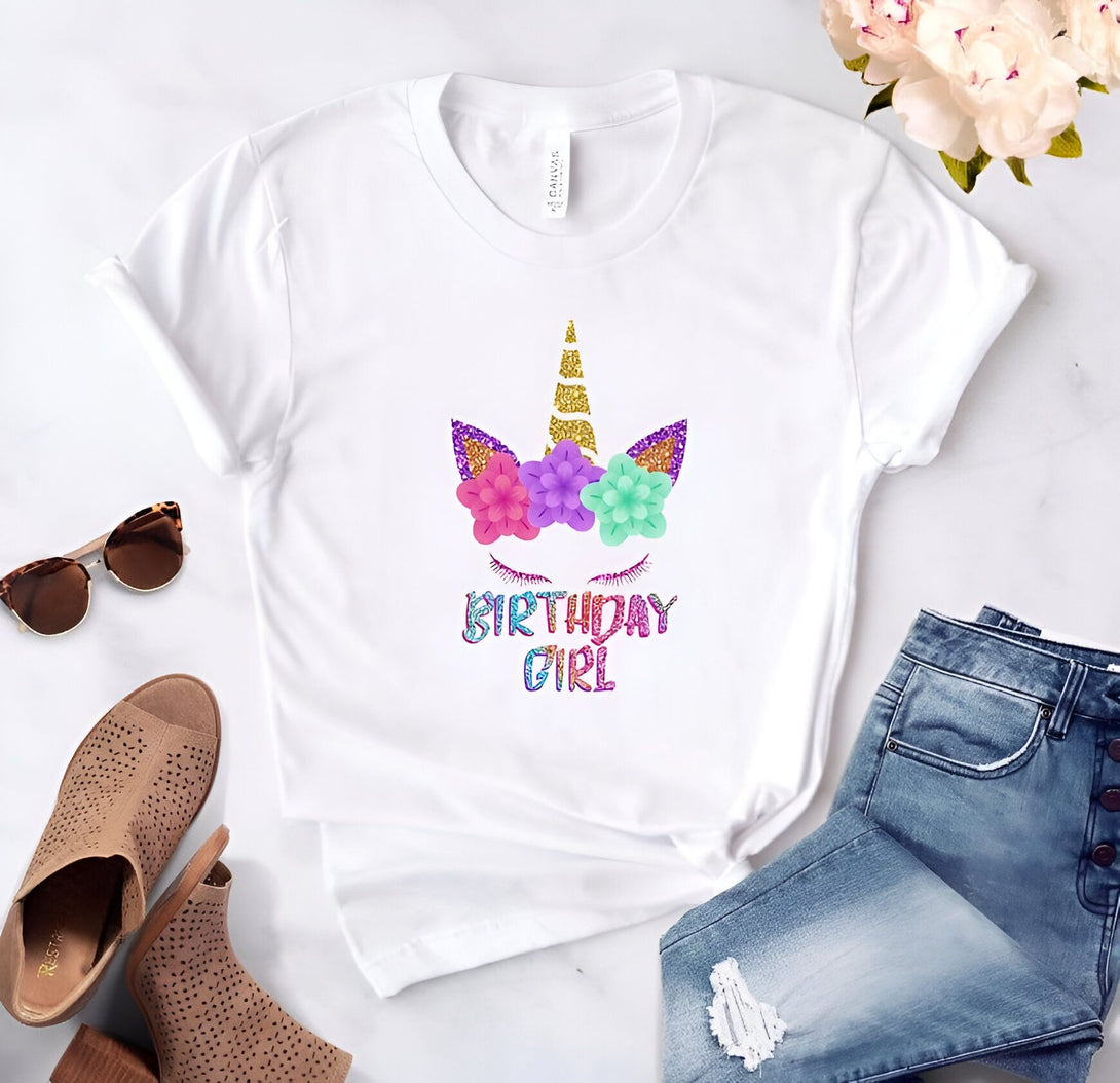 T-shirt blanc avec motif de licorne florale et l'inscription "Birthday Girl". Des lunettes de soleil, des chaussures et un jean sont également visibles. Idée de cadeau d'anniversaire pour fille., 45502331846911,45502331879679,45502331912447,45502331945215,45502331977983,45502332010751,45502332043519,45502332076287 | Licorne Shop