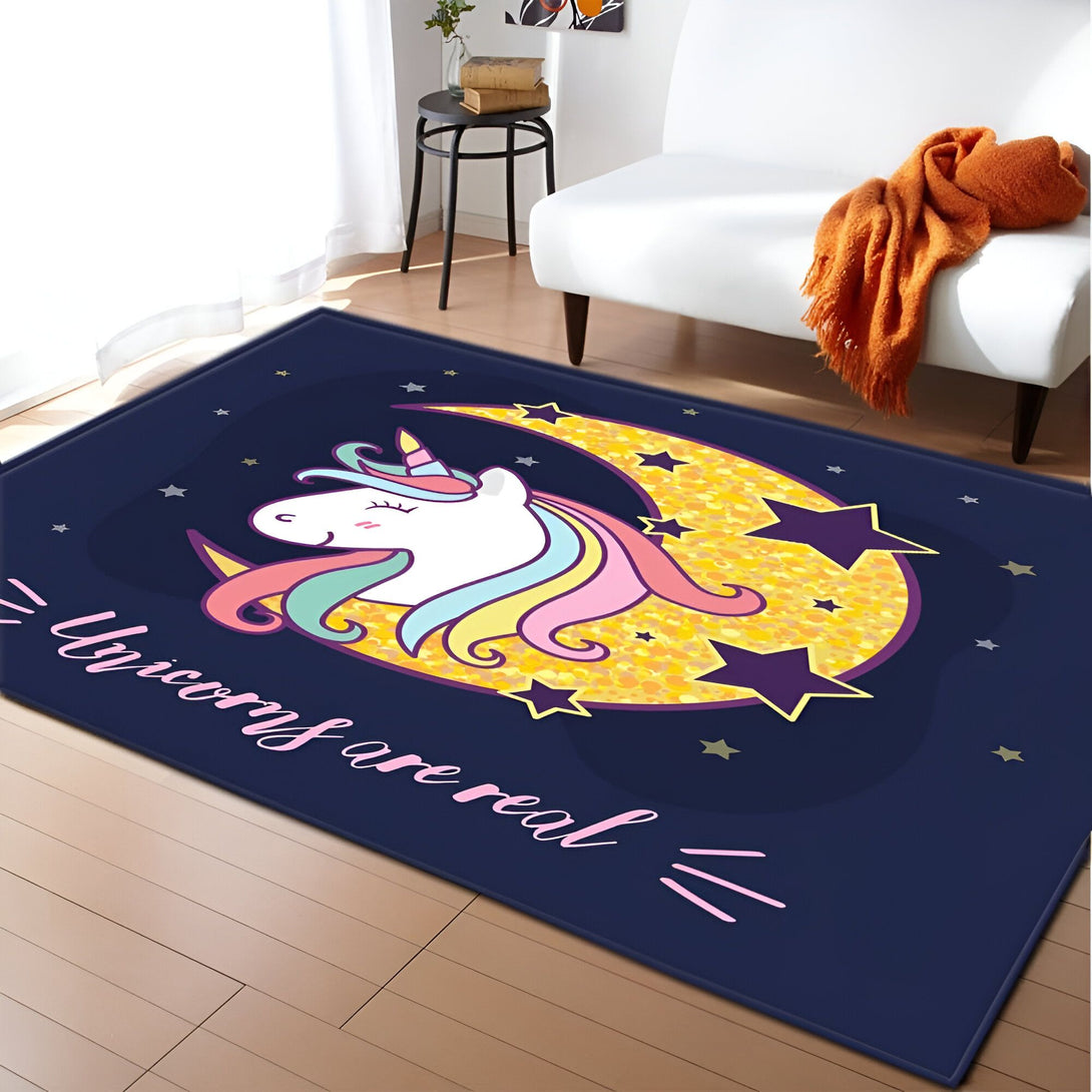 Tapis rectangulaire bleu marine avec un dessin de licorne blanche sur une lune dorée brillante, entourée d'étoiles. L'inscription "Unicorns are real" est visible. Le tapis est posé dans une pièce avec un fauteuil blanc et une couverture orange., 45501064741119 | Licorne Shop