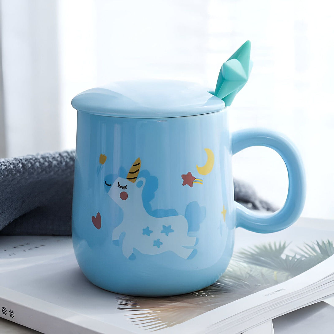 Mug bleu pastel avec couvercle et cuillère en forme de cristal. Décoré d'un motif de licorne, d'une lune et d'étoiles. Idéal pour les boissons chaudes avec une touche de fantaisie., 45501198926079 | Licorne Shop
