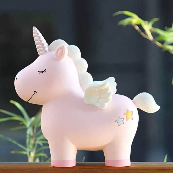 Image d'une tirelire licorne rose avec une crinière blanche, une corne scintillante et des petites ailes blanches. Elle a des étoiles sur son arrière-train. Objet décoratif mignon pour enfants., 45501163503871 | Licorne Shop