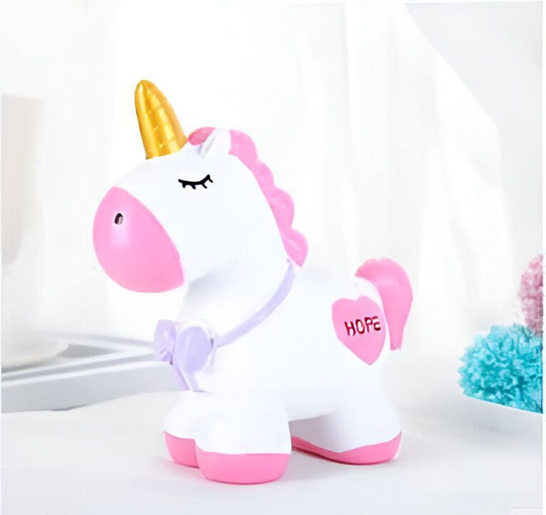 Tirelire licorne blanche avec des accents roses et une corne dorée brillante. L'inscription "Hope" est visible sur un cœur rose sur le flanc. L'objet est placé sur une surface blanche, suggérant un décor de chambre d'enfant., 45501184770303 | Licorne Shop