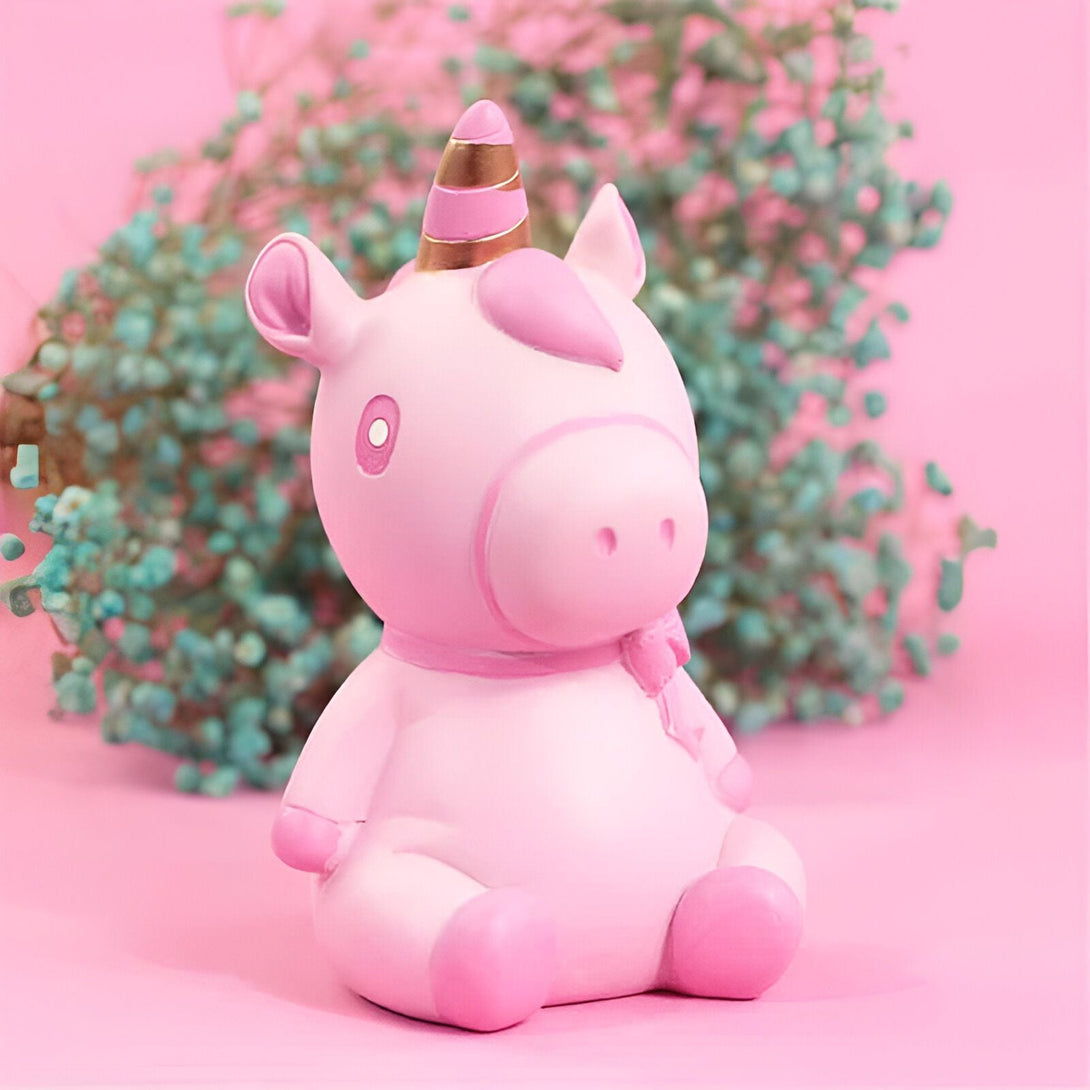 Figurine décorative d'un adorable licorne rose pastel avec une corne dorée, assise devant un fond rose et une touche florale turquoise pour un contraste doux., 45501161275647 | Licorne Shop