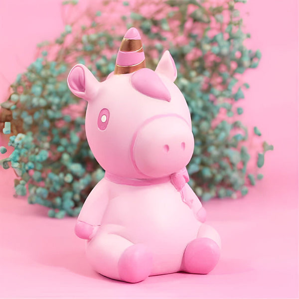 Figurine décorative d'un adorable licorne rose pastel avec une corne dorée, assise devant un fond rose et une touche florale turquoise pour un contraste doux., 45501161275647 | Licorne Shop