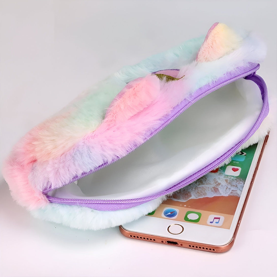 L'image montre une trousse en peluche colorée avec une fermeture éclair. La trousse est ouverte et on peut voir qu'elle est suffisamment grande pour contenir un téléphone portable.