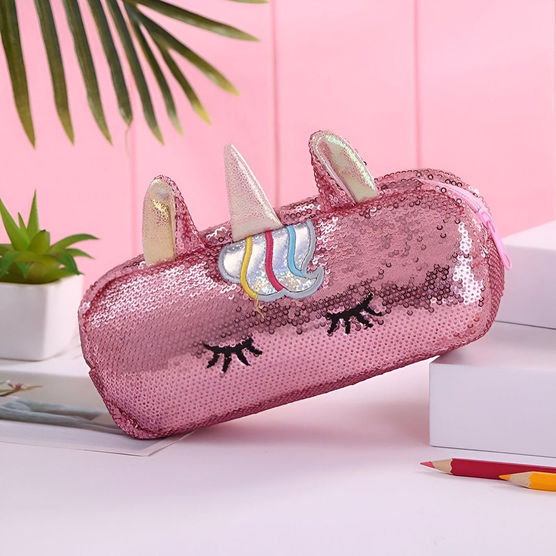 Une trousse rose en forme de licorne avec des paillettes et une fermeture éclair.