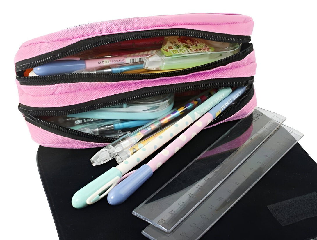 L'image montre une trousse rose à deux compartiments ouverte avec des fournitures scolaires à l'intérieur, notamment des stylos, des crayons, une règle et des ciseaux.