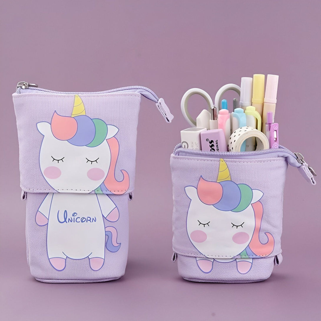 L'image montre une trousse à crayons en forme de licorne. La trousse est de couleur mauve et a une fermeture éclair. Sur le devant de la trousse, il y a une image d'une licorne endormie. La trousse est ouverte et on peut voir qu'il y a des crayons, des stylos et d'autres fournitures scolaires à l'intérieur.