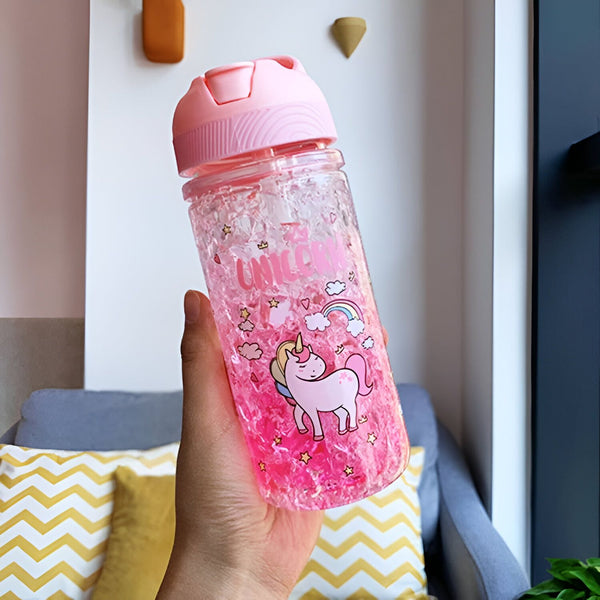 Une main tient une bouteille d'eau rose avec des motifs de licorne et de nuages. Le fond de la bouteille est rempli de cristaux roses, et le bouchon est également rose., 45501178347775 | Licorne Shop
