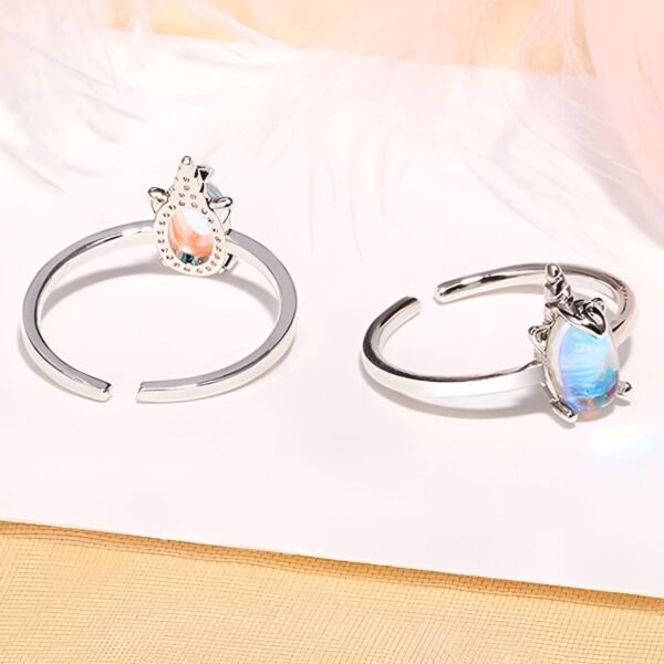 Deux bagues en argent avec une pierre en forme de goutte. L'une a des tons pêche et l'autre des tons bleus irisés. Elles reposent sur un tissu clair., 45502382047487,45502382080255,45502382113023,45502382145791,45502382178559,45502382211327,45502382244095,45502382276863,45502382309631,45502382342399,45502382375167,45502382407935,45502382440703,45502382473471,45502382506239 | Licorne Shop