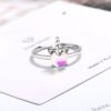 Une bague en argent avec une pierre précieuse opale blanche et rose en forme de licorne.